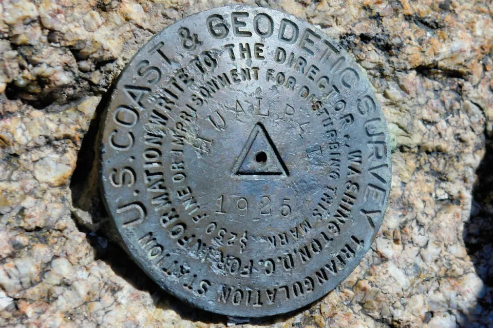 Metal U.S. Geodetic Survey marker in stone in Arizona.
